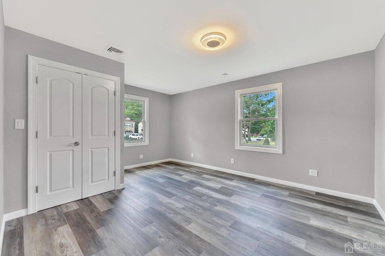 114 Morningside Road Colonia, NJ 07067 - Photo 20 of 27 an empty room with wooden floor and windows