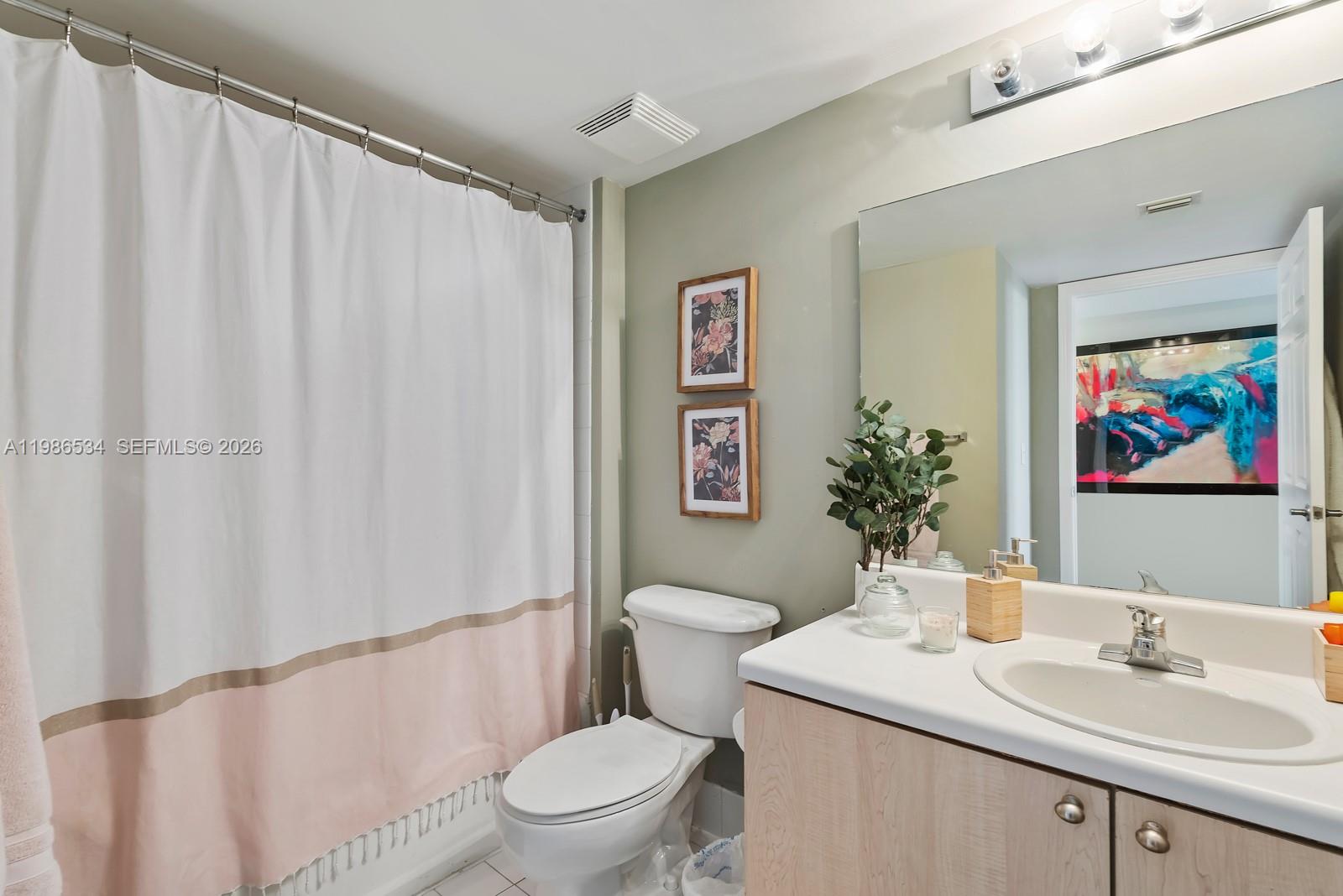 3000 Coral Way, Unit 416 Miami, FL 33145 - Photo 13 of 23 a bathroom with a sink a toilet and shower curtain