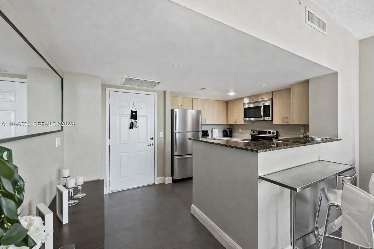 3000 Coral Way, Unit 416 Miami, FL 33145 - Photo 5 of 23 a kitchen with stainless steel appliances granite countertop a refrigerator and a stove top oven