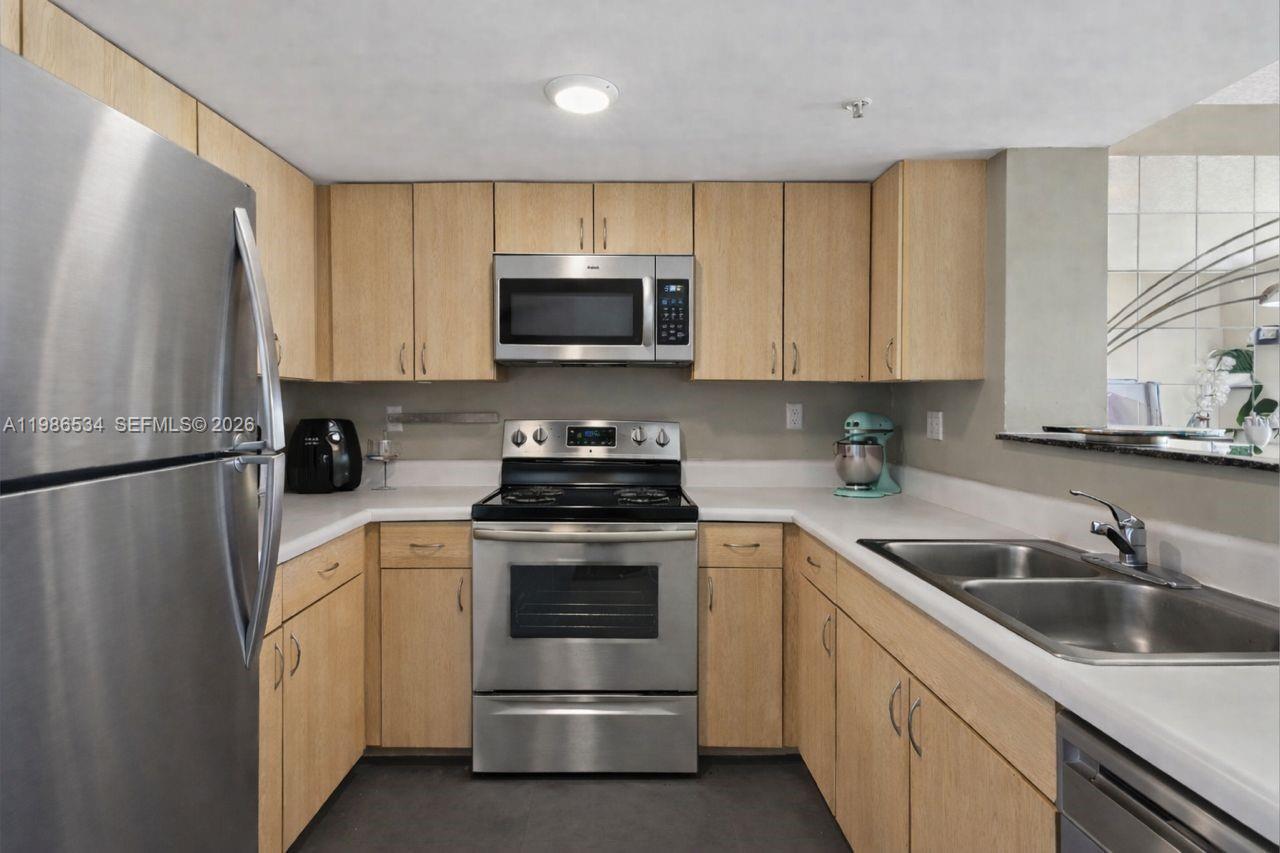3000 Coral Way, Unit 416 Miami, FL 33145 - Photo 7 of 23 a kitchen with white cabinets sink and stainless steel appliances