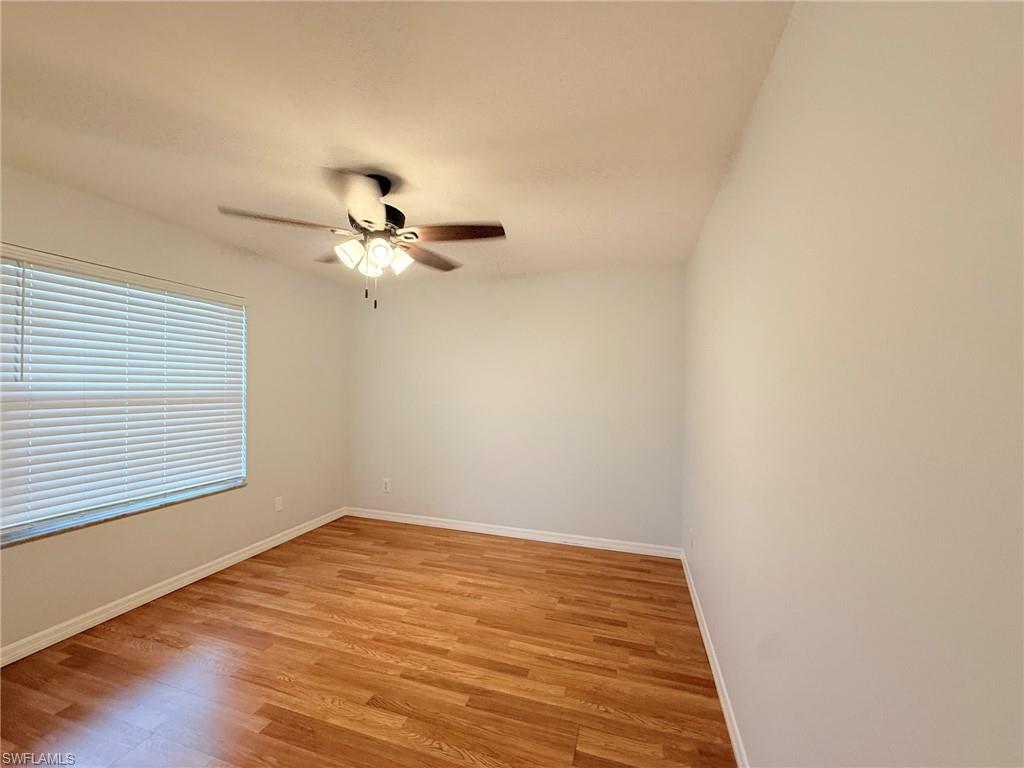 27595 Imperial River Road Bonita Springs, FL 34134 - Photo 17 of 28 a view of a room with wooden floor and a ceiling fan