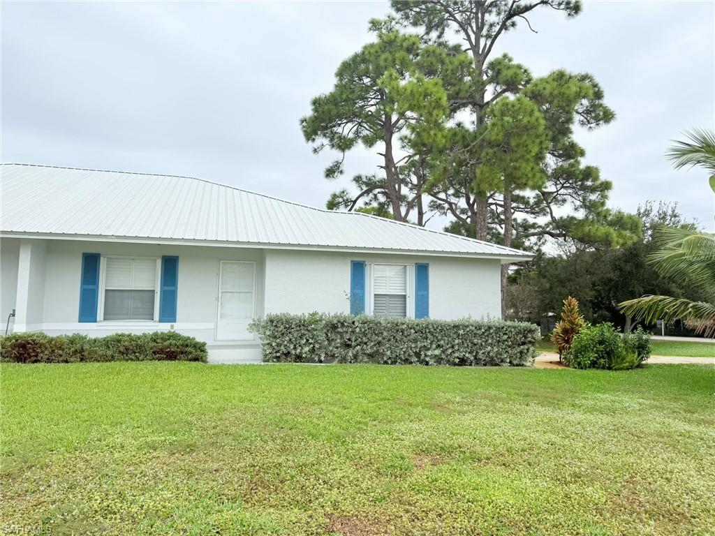 27595 Imperial River Road Bonita Springs, FL 34134 - Photo 2 of 28 a front view of a house with garden