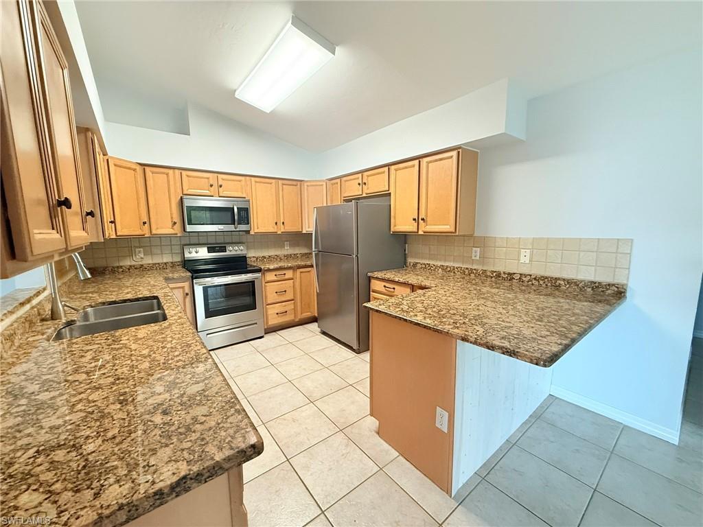 27595 Imperial River Road Bonita Springs, FL 34134 - Photo 7 of 28 a kitchen with stainless steel appliances granite countertop a sink stove and refrigerator