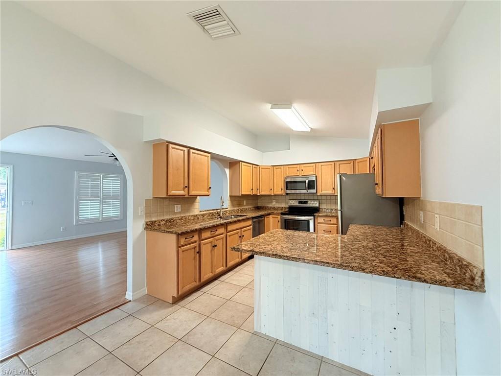 27595 Imperial River Road Bonita Springs, FL 34134 - Photo 9 of 28 a large kitchen with granite countertop a sink and white cabinets