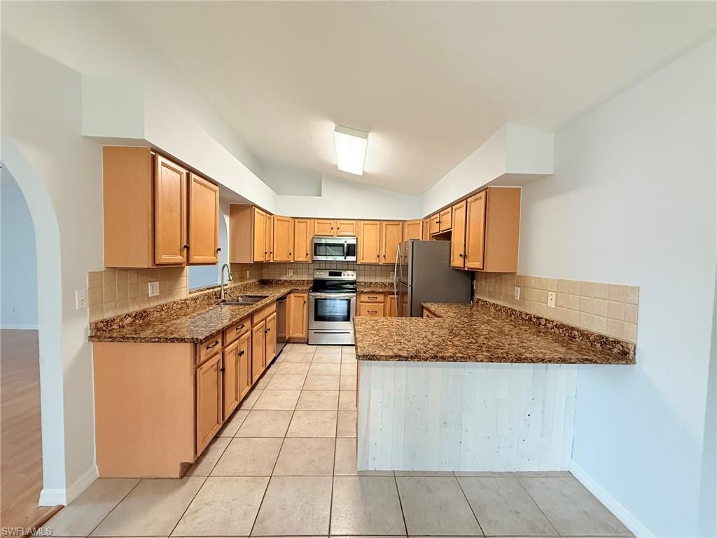 27595 Imperial River Road Bonita Springs, FL 34134 - Photo 10 of 28 a large kitchen with stainless steel appliances granite countertop a stove and a sink