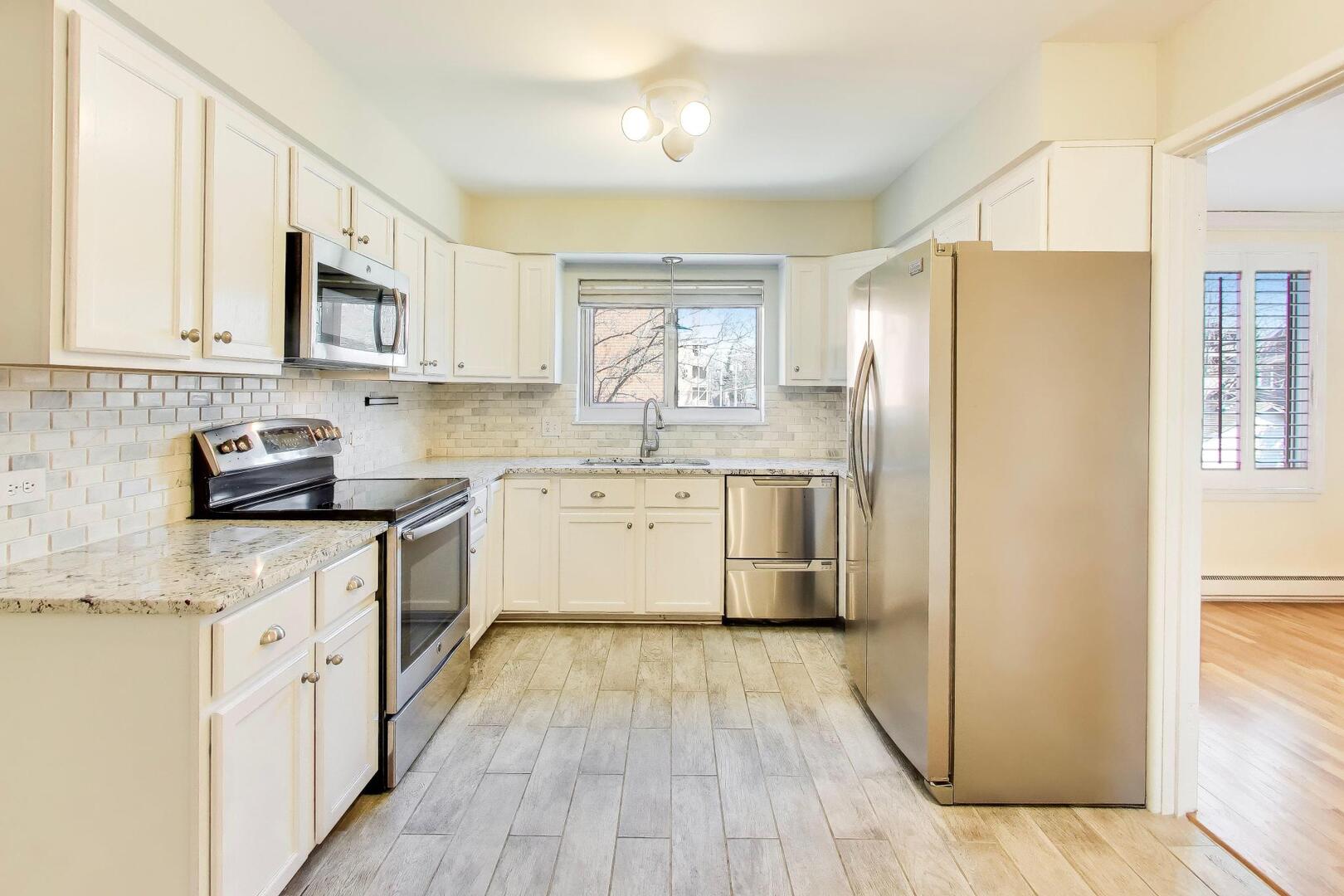 2324 Central Street, Unit 2B Evanston, IL 60201 - Photo 11 of 28 a kitchen with a white cabinets and wooden floor