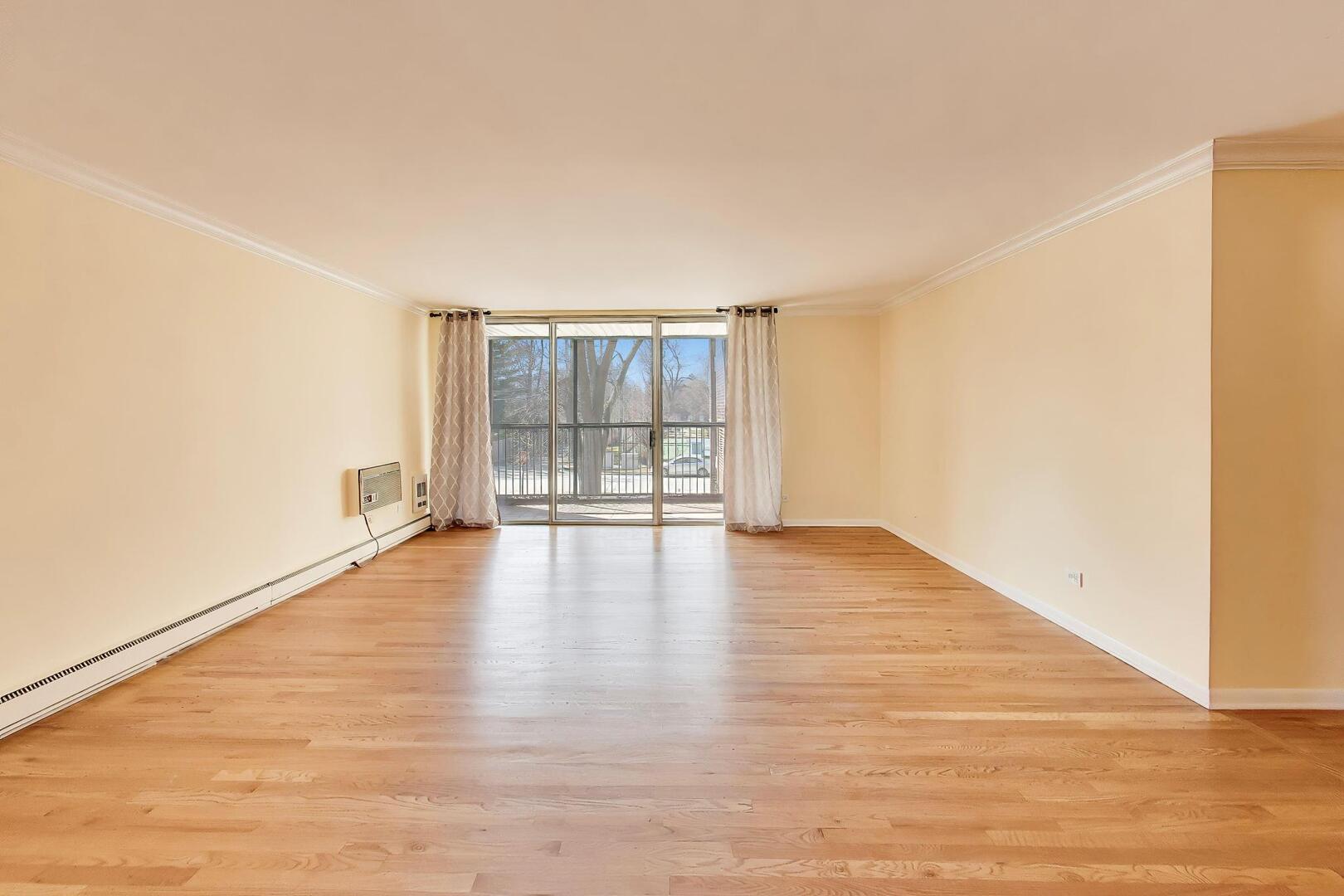 2324 Central Street, Unit 2B Evanston, IL 60201 - Photo 7 of 28 a view of an empty room with wooden floor and a window