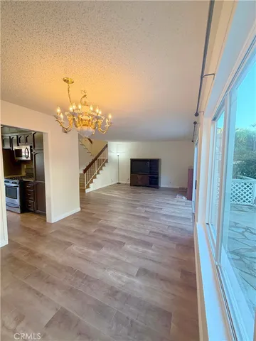 a view of a livingroom with wooden floor and stairs