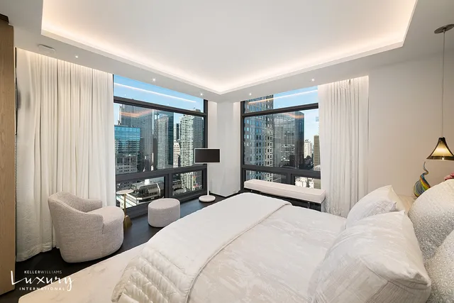 a spacious bedroom with a bed and glass windows