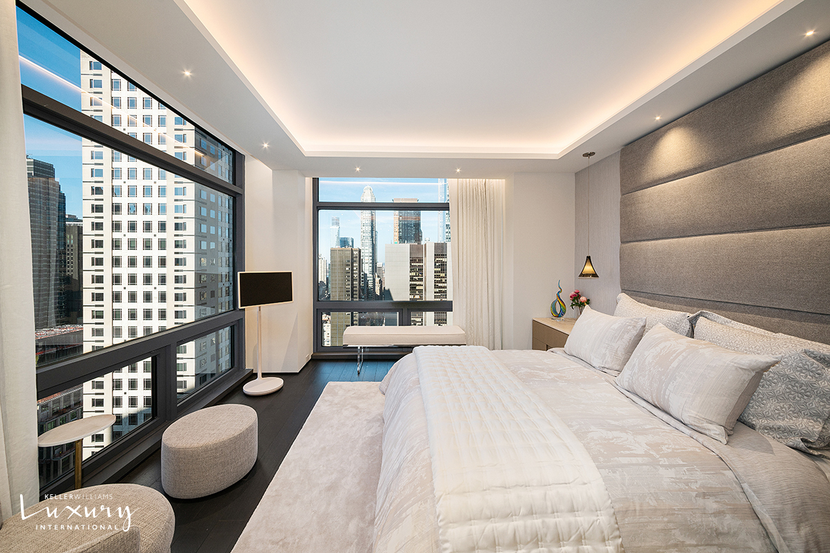 721 5th Avenue, Unit 41H Manhattan, NY 10022 - Photo 9 of 15 a spacious bedroom with a bed and glass windows