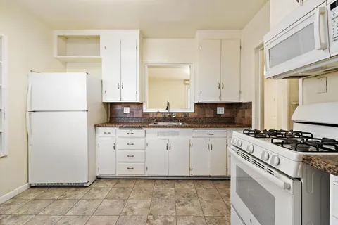 a kitchen with cabinets appliances and a window