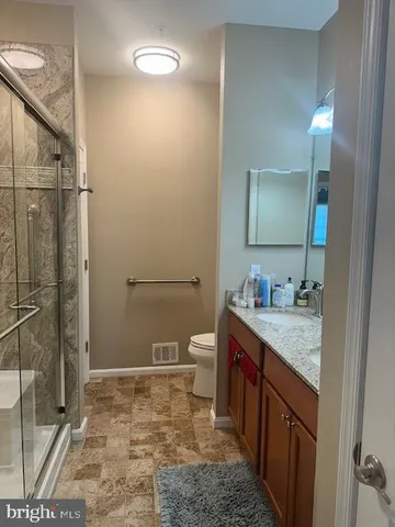 a bathroom with a granite countertop sink toilet and shower
