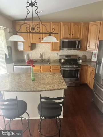 a kitchen with stainless steel appliances granite countertop a sink and stove