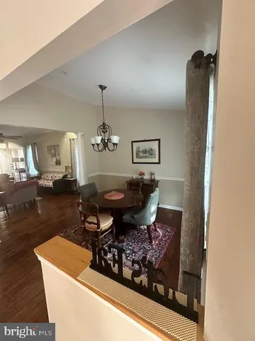 a living room with a couch and a dining table with wooden floor