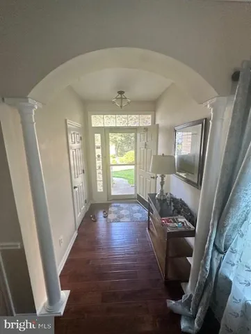 a view of a hallway to a livingroom with furniture wooden floor and window