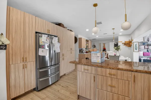 a kitchen with stainless steel appliances granite countertop a refrigerator a sink and a stove