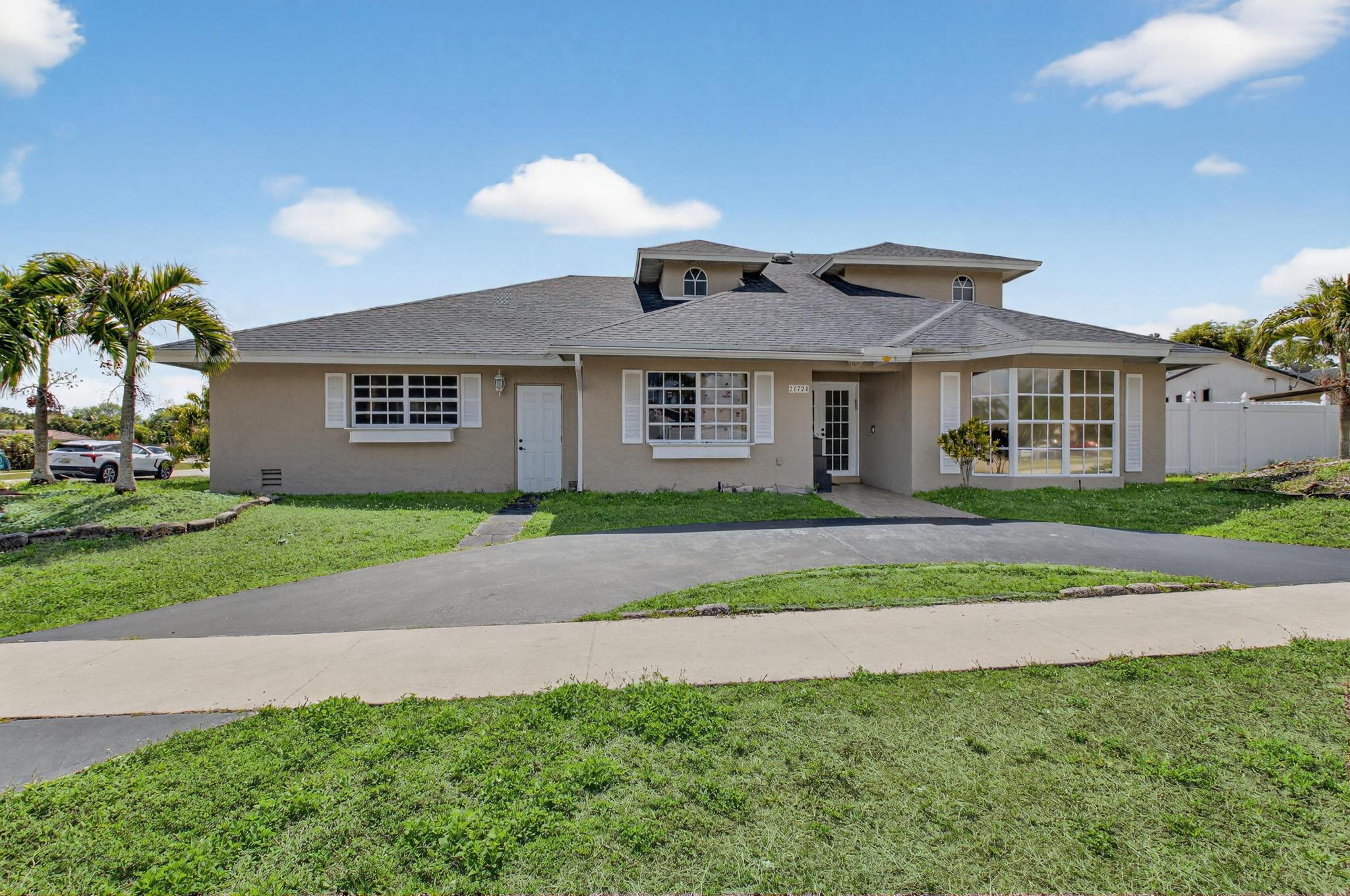 21724 Little Bear Way Boca Raton, FL 33428 - Photo 2 of 47 a front view of a house with a yard and garage