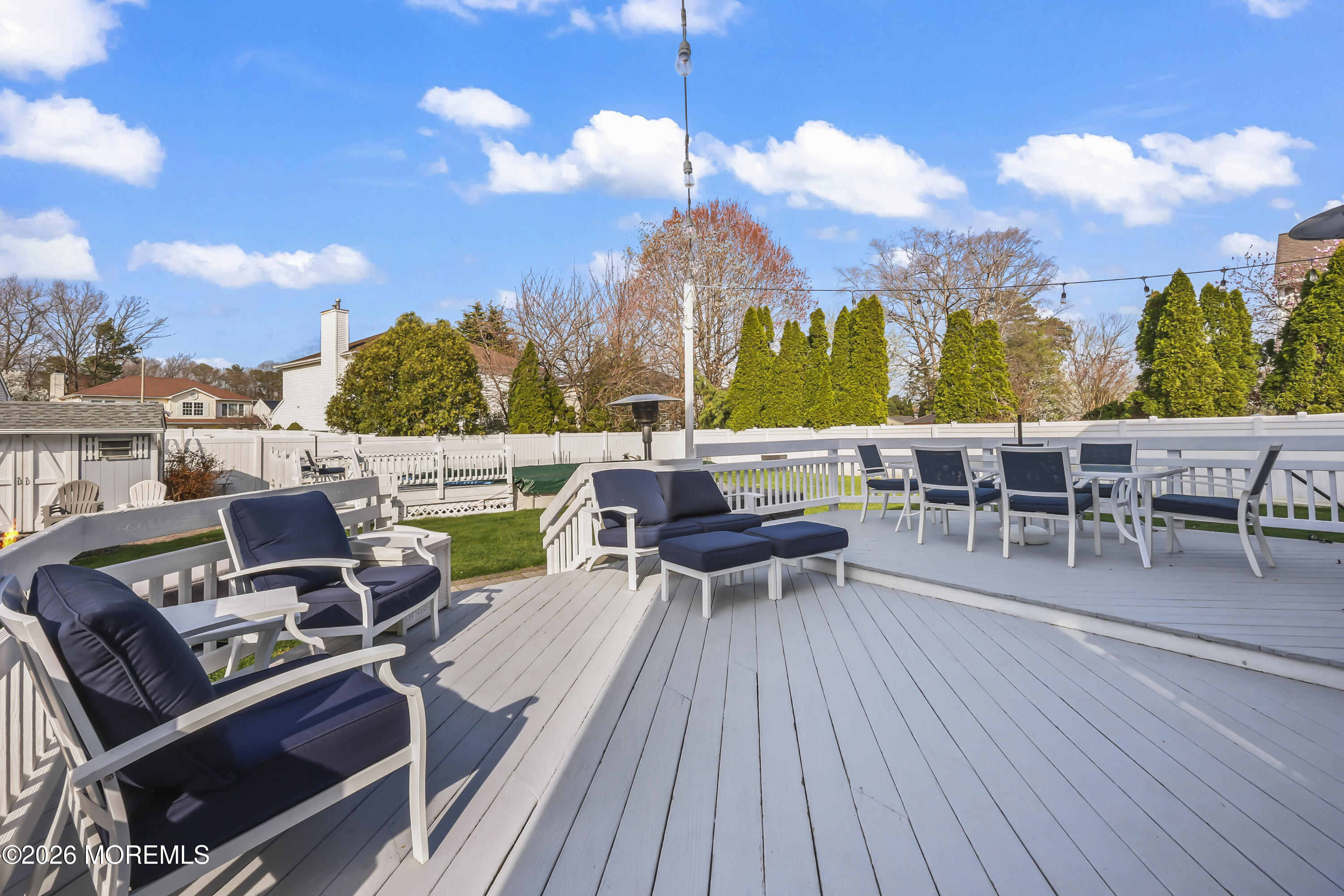17 Sun Hollow Road Howell, NJ 07731 - Photo 37 of 43 a view of a roof deck with table and chairs couches with wooden floor