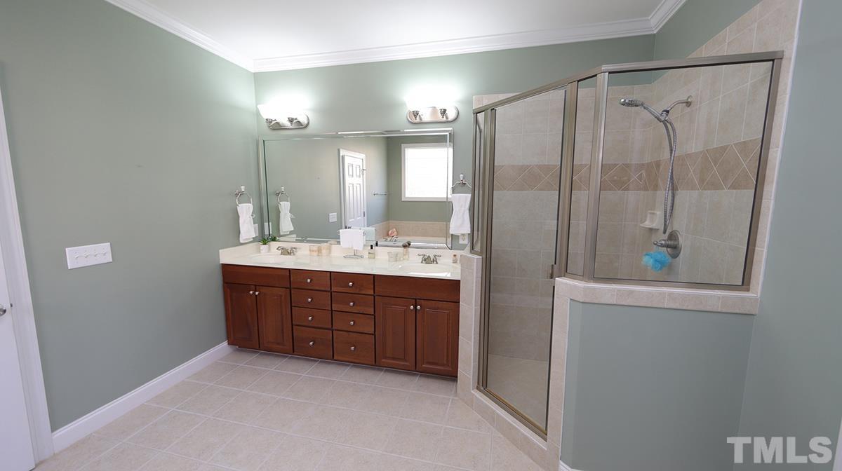263 Waterville Street Raleigh, NC 27603 - Photo 13 of 18 a bathroom with a double vanity sink a toilet and shower