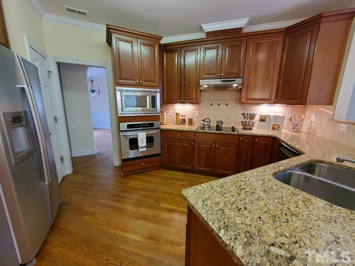 263 Waterville Street Raleigh, NC 27603 - Photo 15 of 18 a kitchen with stainless steel appliances granite countertop a sink stove microwave and refrigerator