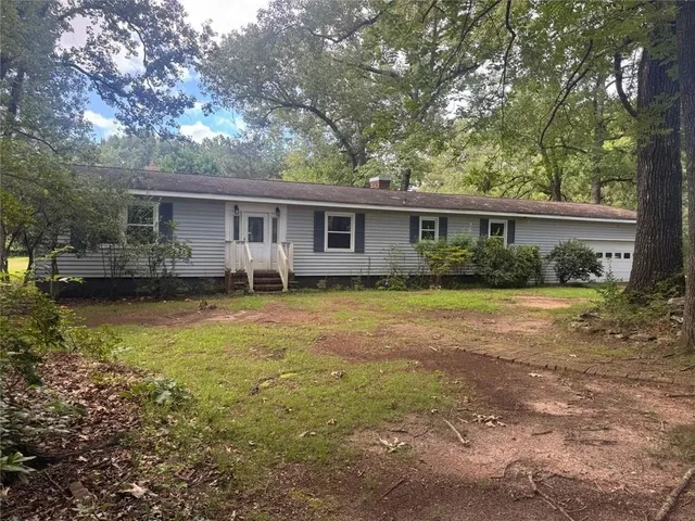 a view of a house with backyard and sitting area