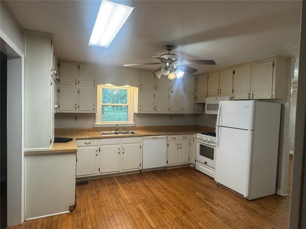 2550 Conyers Road McDonough, GA 30252 - Photo 12 of 29 a kitchen with a refrigerator a sink and dishwasher with white cabinets