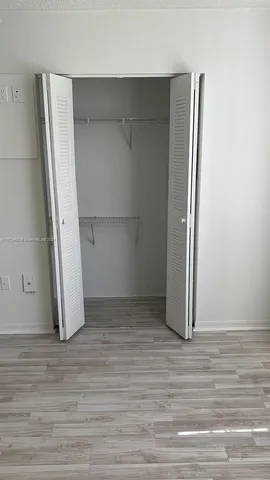 an empty room with wooden floor and closet