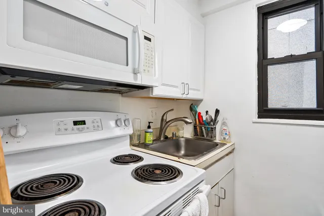 a kitchen with a sink a stove and cabinets