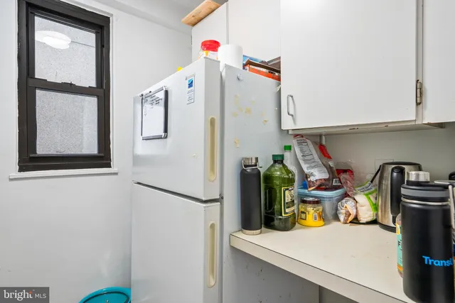 a view of a kitchen with sink and refrigerator
