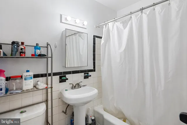 a bathroom with a sink a mirror and a shower curtain