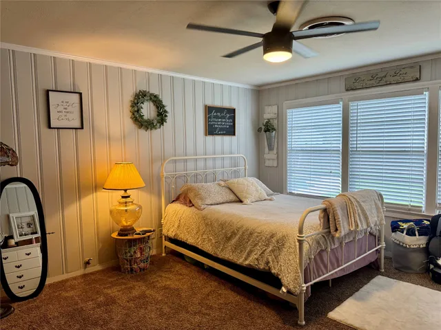 a bedroom with a bed and a painting on the wall