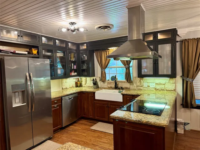 a large kitchen with stainless steel appliances kitchen island granite countertop a sink and cabinets