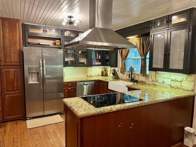 a kitchen with stainless steel appliances granite countertop a sink and a refrigerator