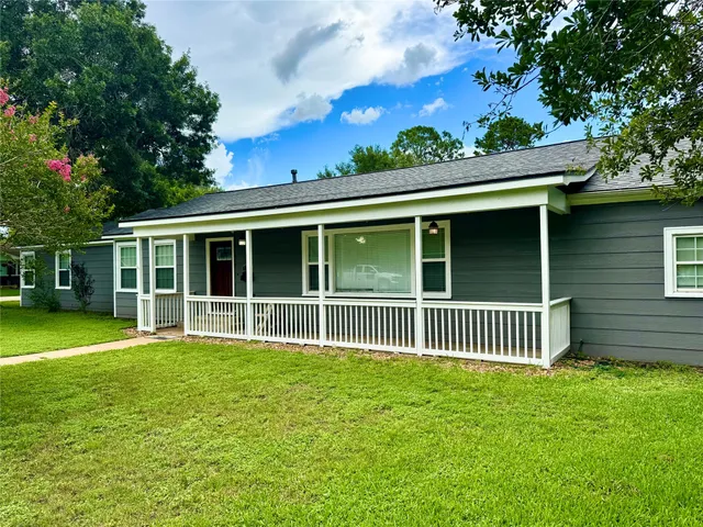a view of a house with a yard and a garden