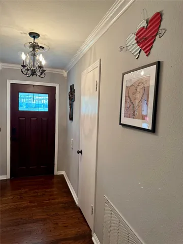 a view of a hallway with wooden floor and chandelier