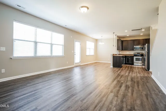 a view of a kitchen with a window and wooden floor