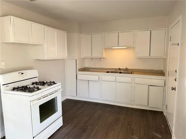 a kitchen with granite countertop white cabinets and white appliances