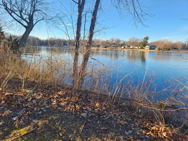 a backyard of a house with lots of green space and lake view