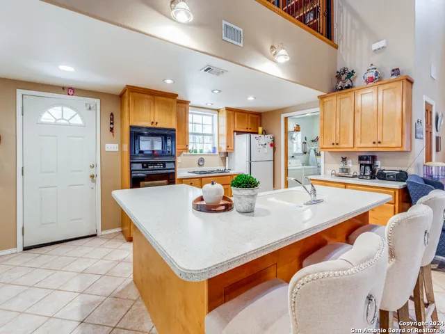 a kitchen with stainless steel appliances granite countertop a sink a stove and a refrigerator