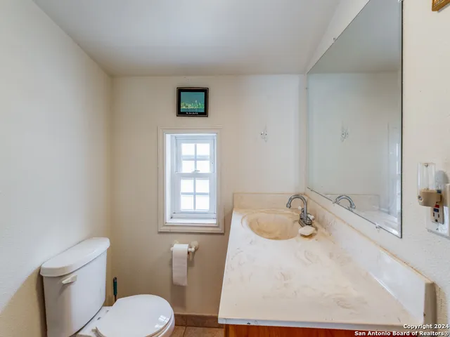 a bathroom with a sink toilet and window