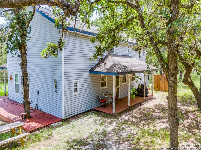 a view of a house with backyard and wooden fence