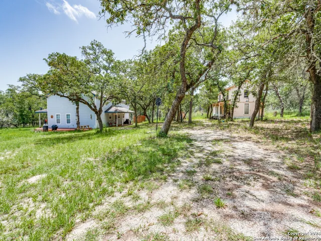a view of a house with backyard and tree
