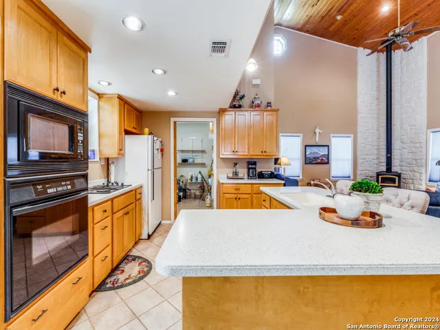 a large kitchen with a large window and stainless steel appliances