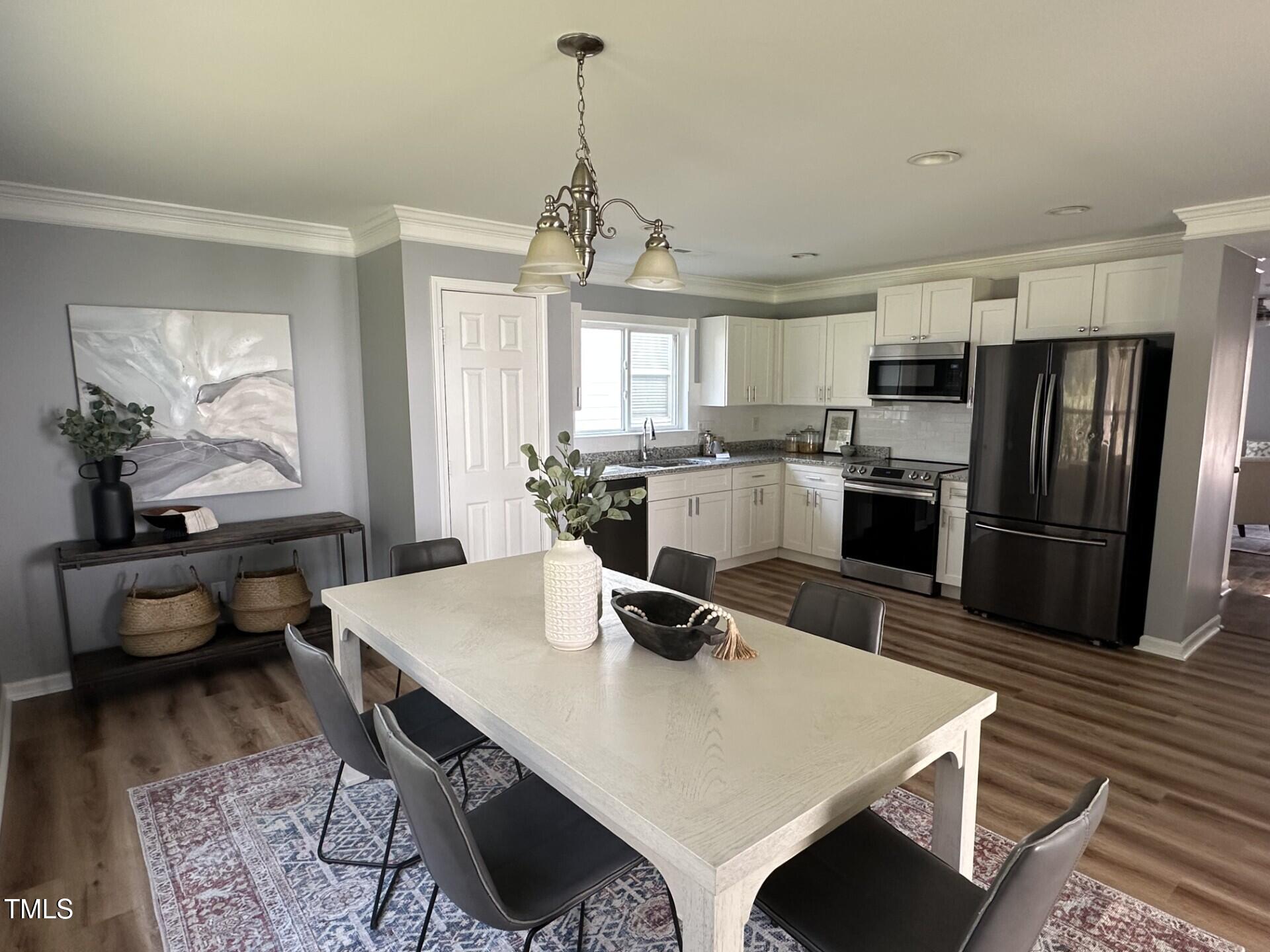336 New Milford Road Cary, NC 27519 - Photo 11 of 53 a kitchen with a refrigerator a stove a sink dishwasher a dining table and chairs with wooden floor