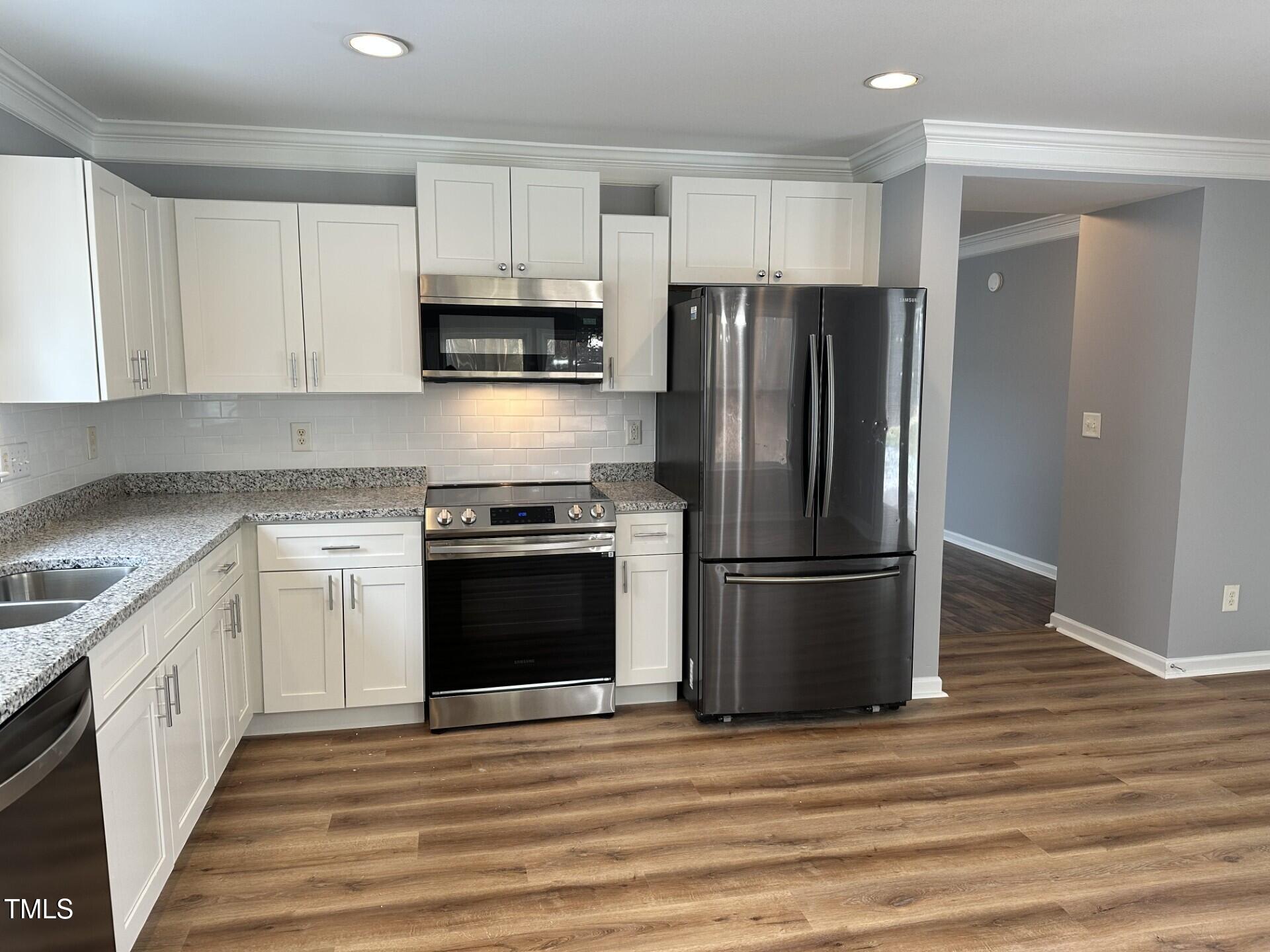 336 New Milford Road Cary, NC 27519 - Photo 14 of 53 a kitchen with a refrigerator stove and white cabinets