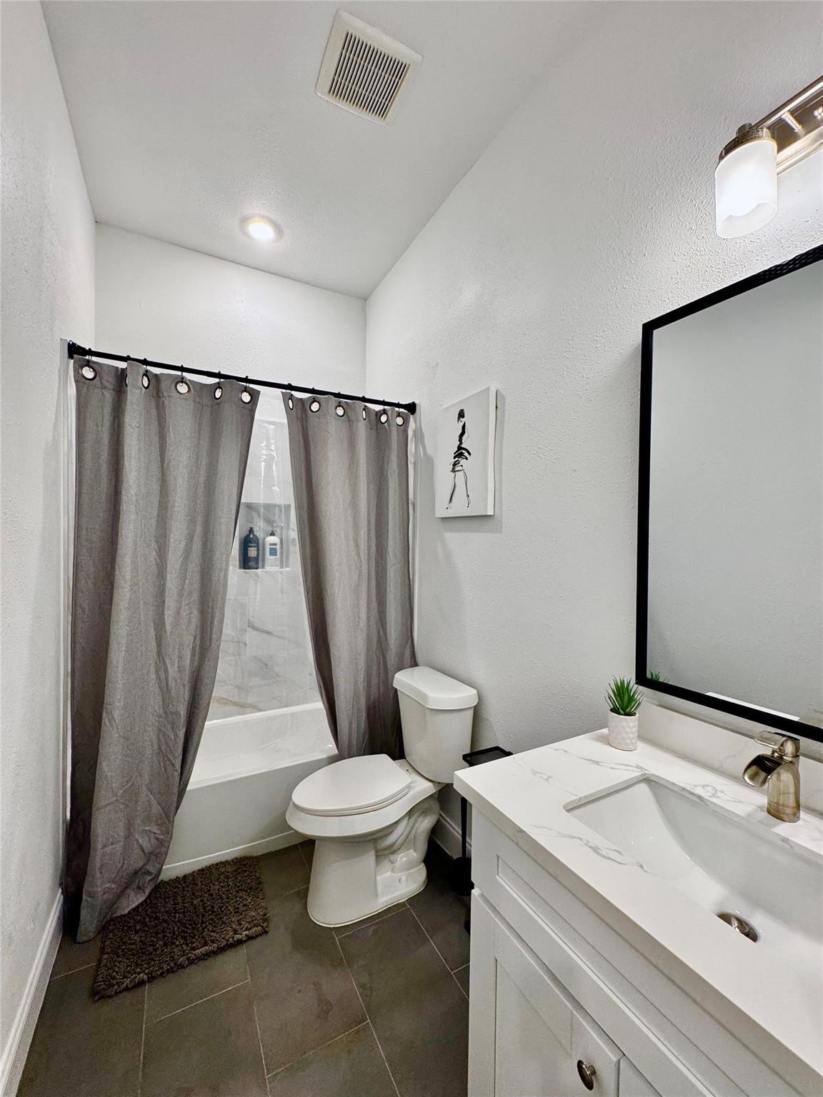 5306 Ridgeway Drive, Unit A Houston, TX 77033 - Photo 9 of 14 Full Bathroom – Well-appointed bathroom featuring a spacious vanity with stone-look countertop, large framed mirror, modern fixtures, and a tub/shower combination.