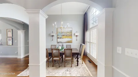 a large kitchen with stainless steel appliances a stove a sink and a view of living room