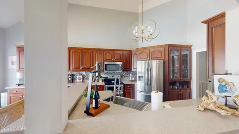 a kitchen with stainless steel appliances kitchen island granite countertop a refrigerator a stove and a sink with dishwasher