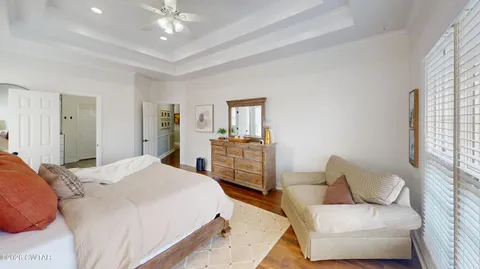 a bedroom with a large bed and a chandelier