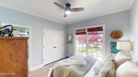 a bedroom with furniture and a large window